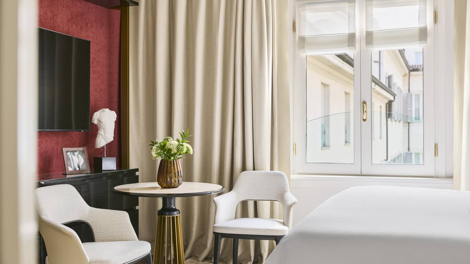 Hotel room featuring a small round table and two contemporary chairs