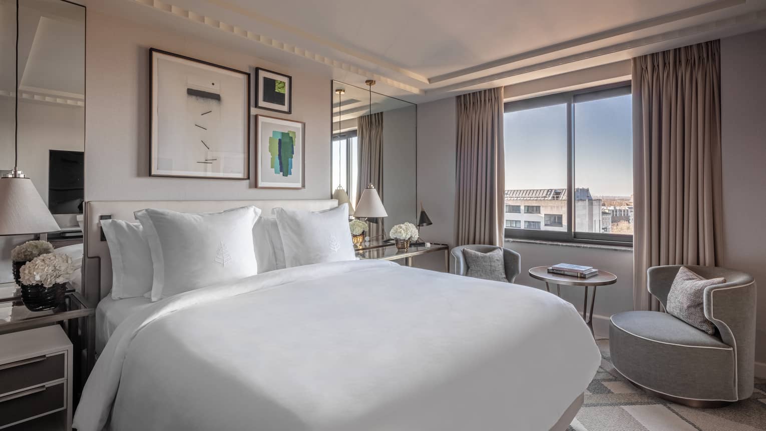 Superior room at the Four Seasons London Park Lane in Mayfair, offering a blend of comfort and luxury. The room features a large, king-sized bed covered in crisp white linens, surrounded by tasteful decor including muted gray curtains, elegant lamps, and a selection of framed artworks on the walls. A comfortable seating area by the window provides a relaxing space with a curved armchair and a small table, perfect for enjoying the city views. The room's modern and understated elegance is emphasised by its clean lines and soft colour palette,Superior Room at Four Seasons London Park Lane in Mayfair, offering a blend of comfort and luxury. The room features a large, king-sized bed covered in crisp white linens, surrounded by tasteful decor, including muted gray curtains, elegant lamps and a selection of framed artworks on the walls. A comfortable seating area by the window provides a relaxing space with a curved armchair and a small table, perfect for enjoying the city views. The room's modern and understated elegance is emphasized by its clean lines and soft colour palette.
