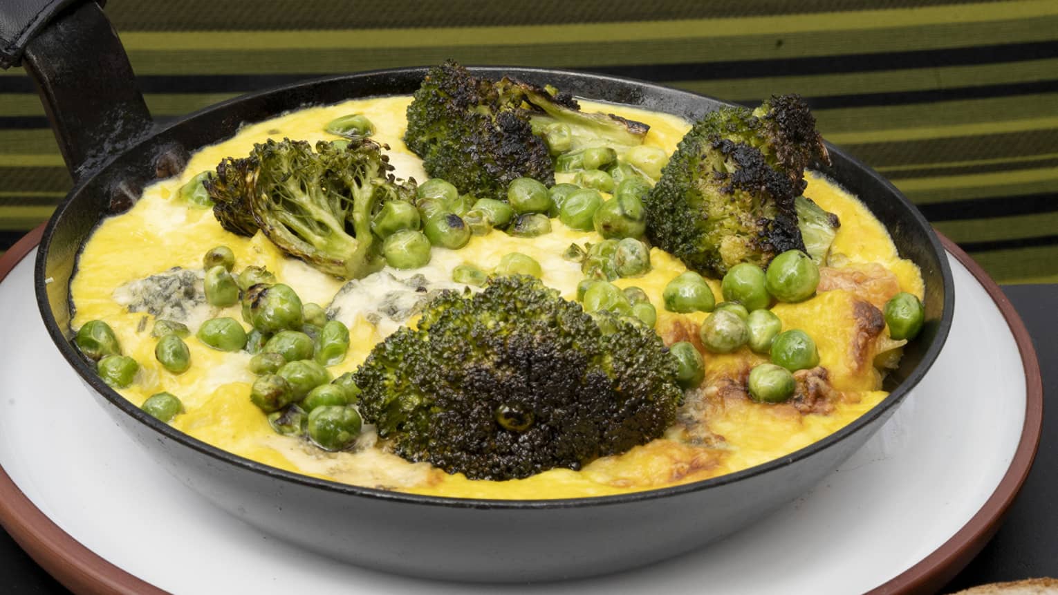 Conchiglio pasta with corn cream, broccoli, blue cheese, green beans and au gratin boconccinos served in a cast iron skillet