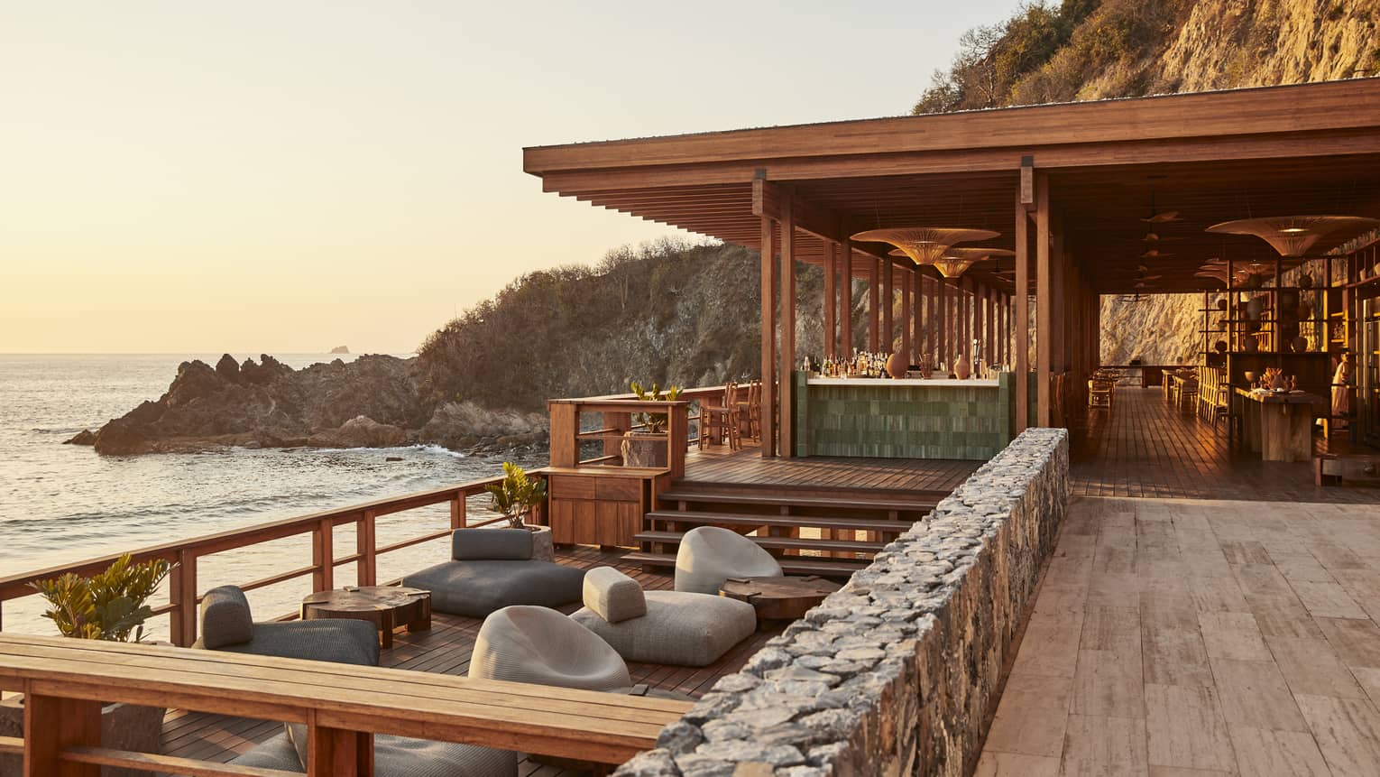AN outdoor lounge area next to the ocean.