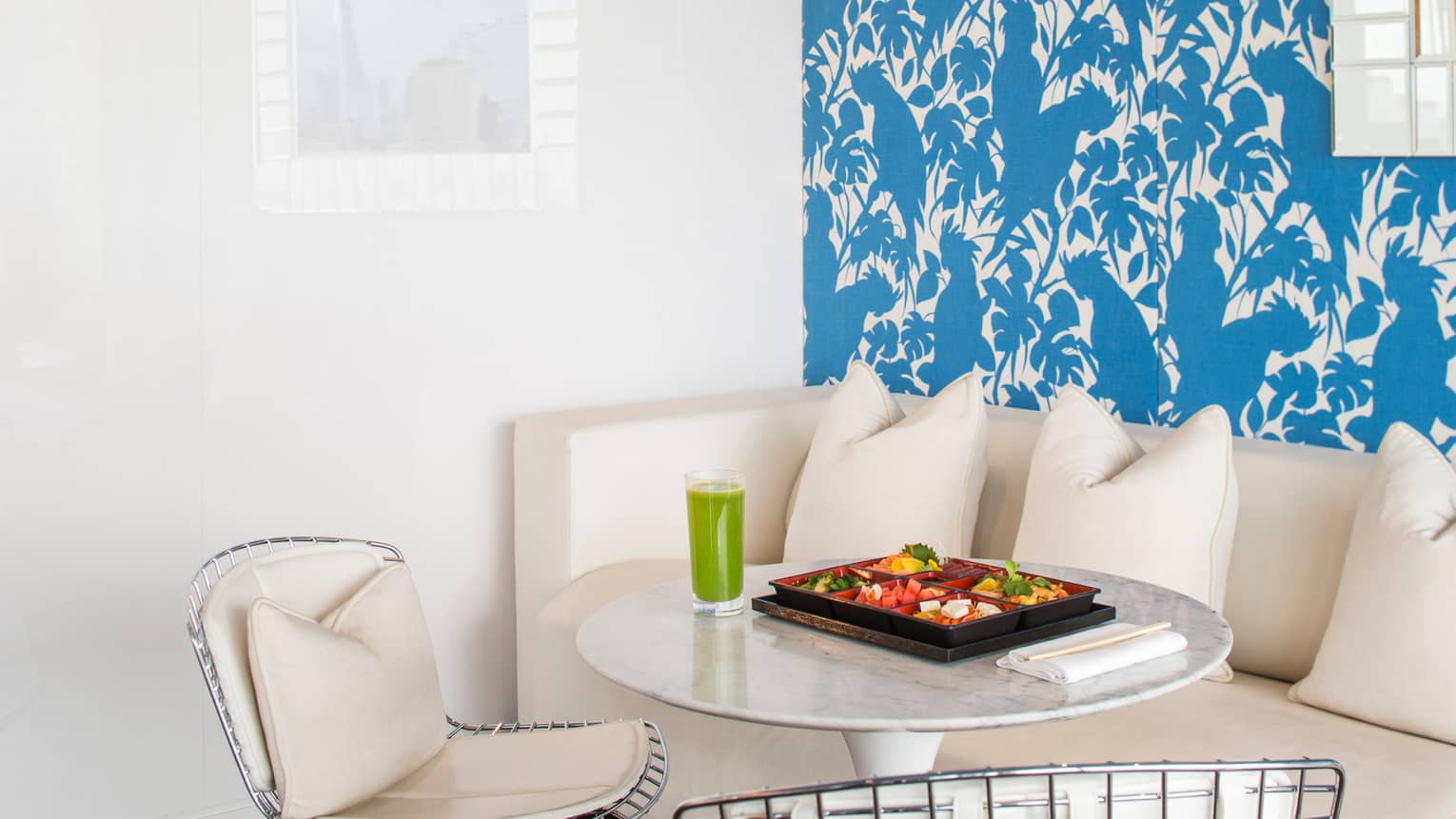 Small spa dining table with cheese, fruit in tray, glass with green smoothie