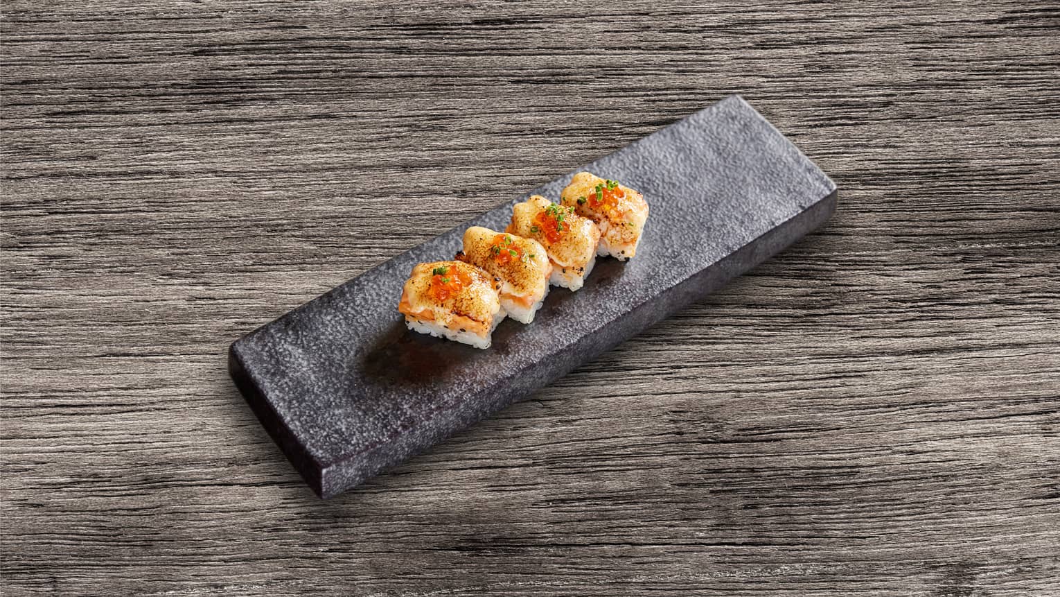 Sushi on a black tray.