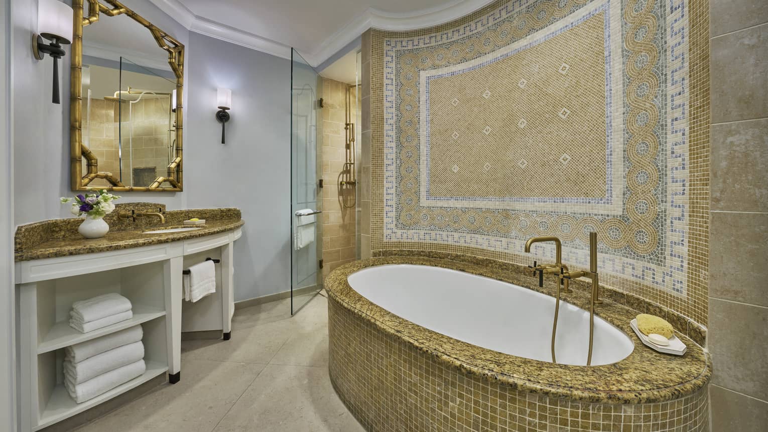 Luxury bathroom with a mosaic-tiled bathtub, ornate wall design, large mirror, vanity and glass-enclosed shower area