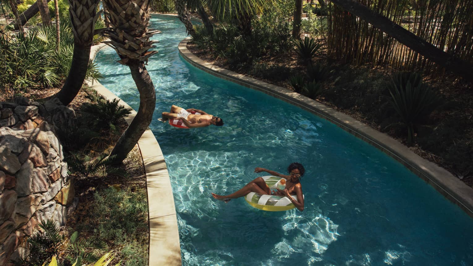 Two guests on floats on the lazy river.