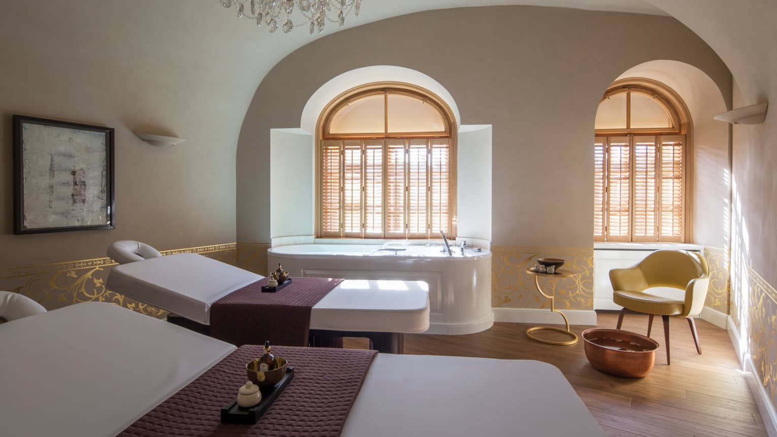 Two white beds beside spa tub in dimly-lit room at the Vltava Suite at AVA Spa
