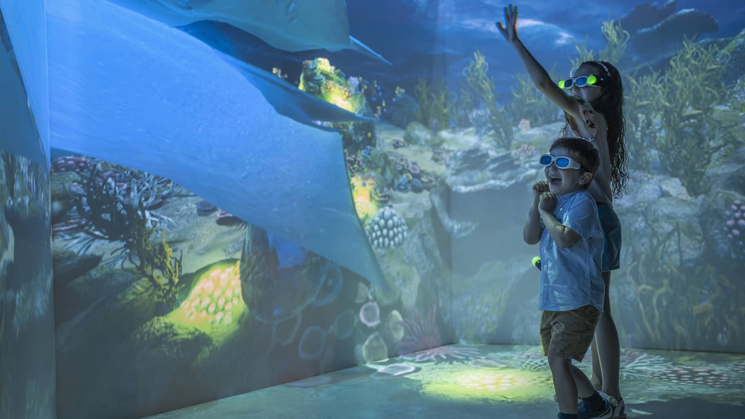 Young girl and boy wearing 3D glasses in the Hologram Room at the Marine Discovery Centre