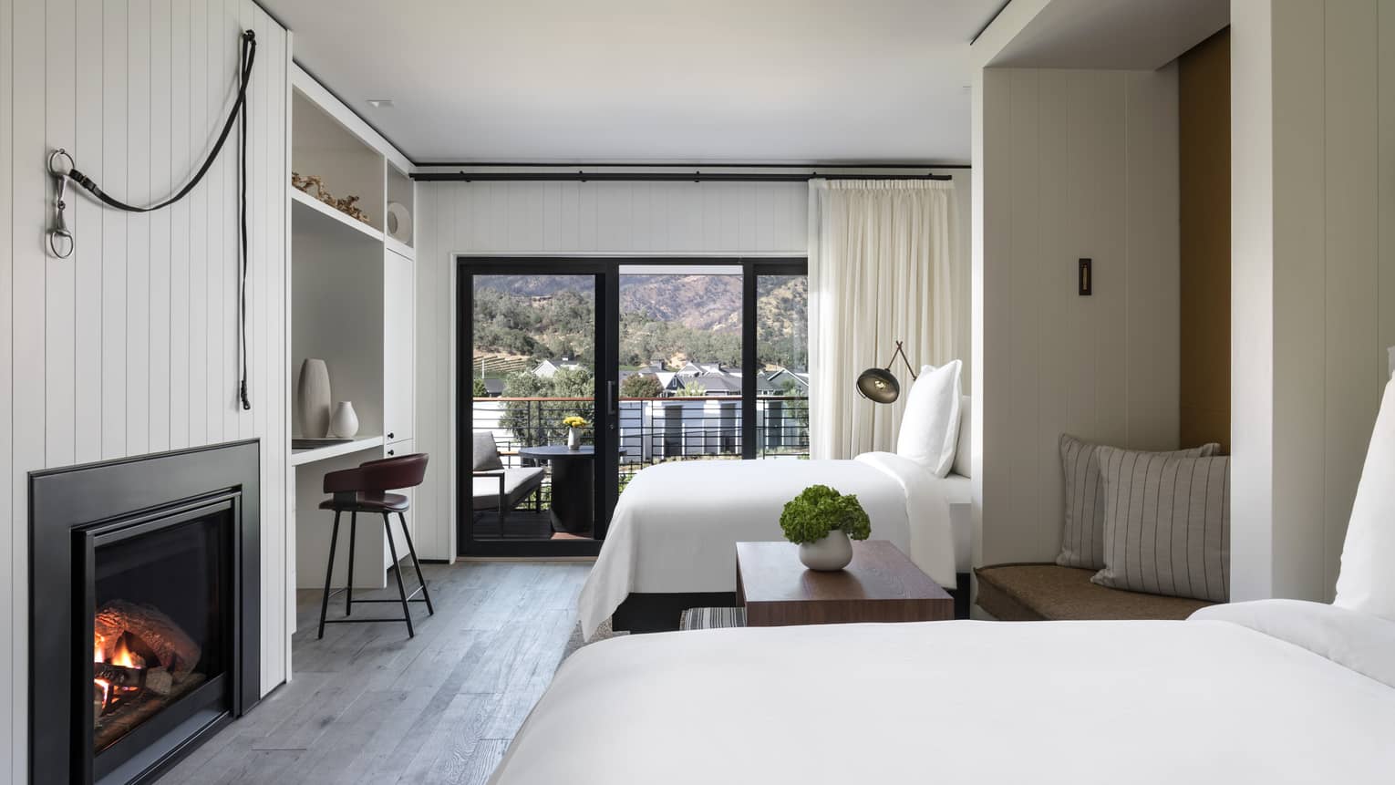 Hotel room with two double beds, wood floors, fireplace, walk-out terrace