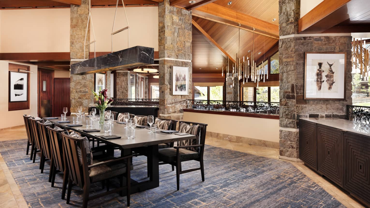 Elegant restaurant dining table with fresh-cut flowers and ten seats on the upper level of Westbank Grill