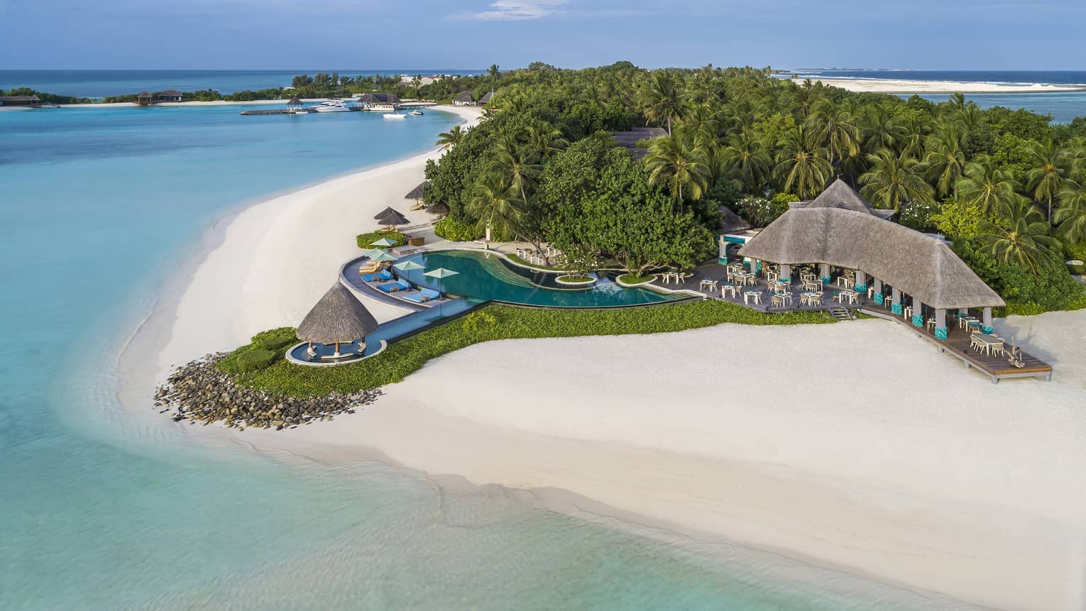 An aerial view of the turquoise water lapping the white sand beach shore near the reef club's terrace 