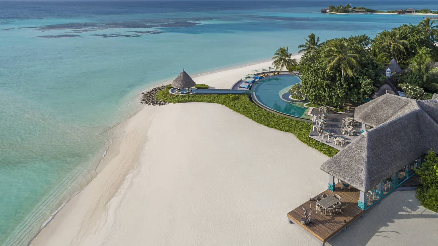 An aerial view of the turquoise water lapping the white sand beach shore near the reef club's terrace 