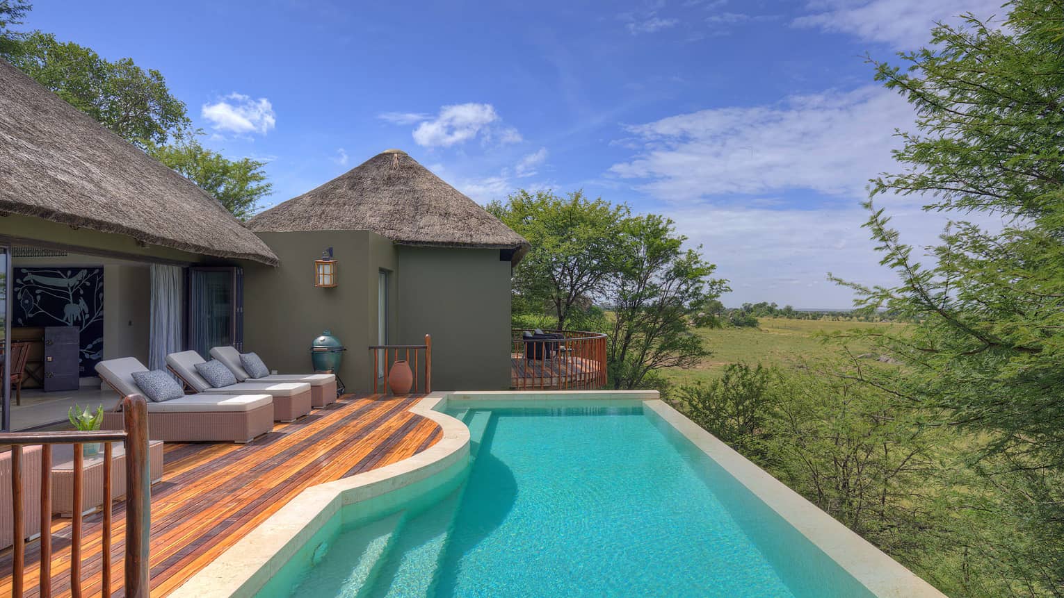 Private pool at a plain?s edge with lounge chairs on wooden decking