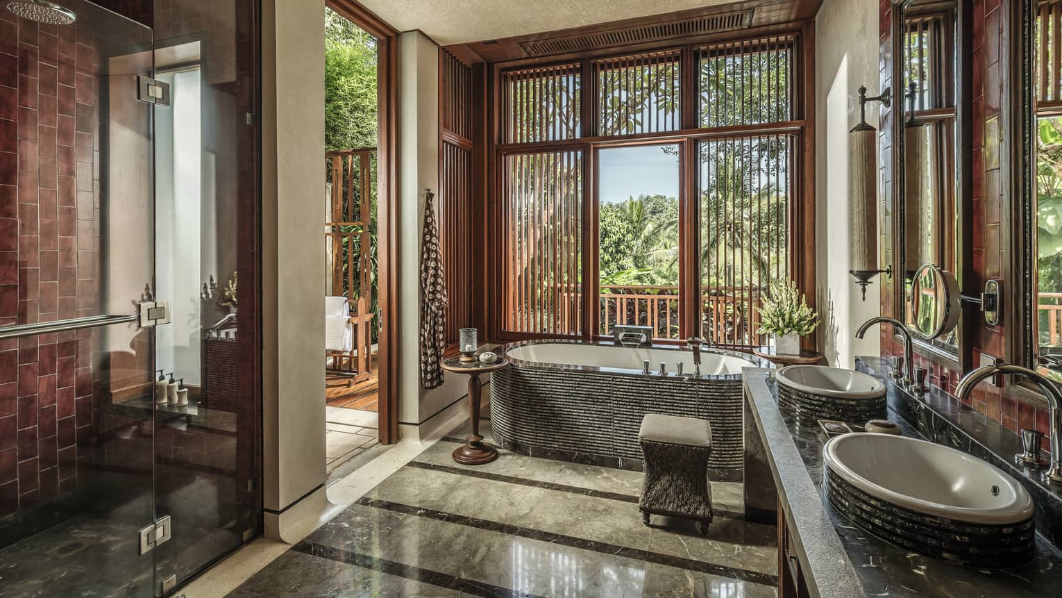 A sunlit bathroom with a tub and two sinks 