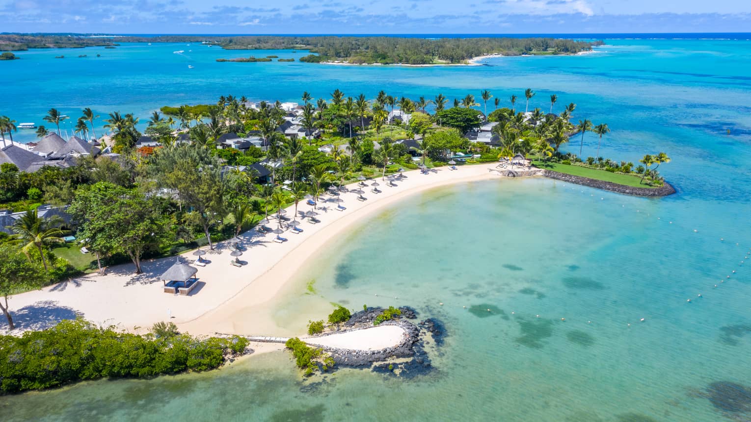 Aerial view of Four Seasons Resort Mauritius at Anahita and surroundings, including white-sand crescent beach and ocean