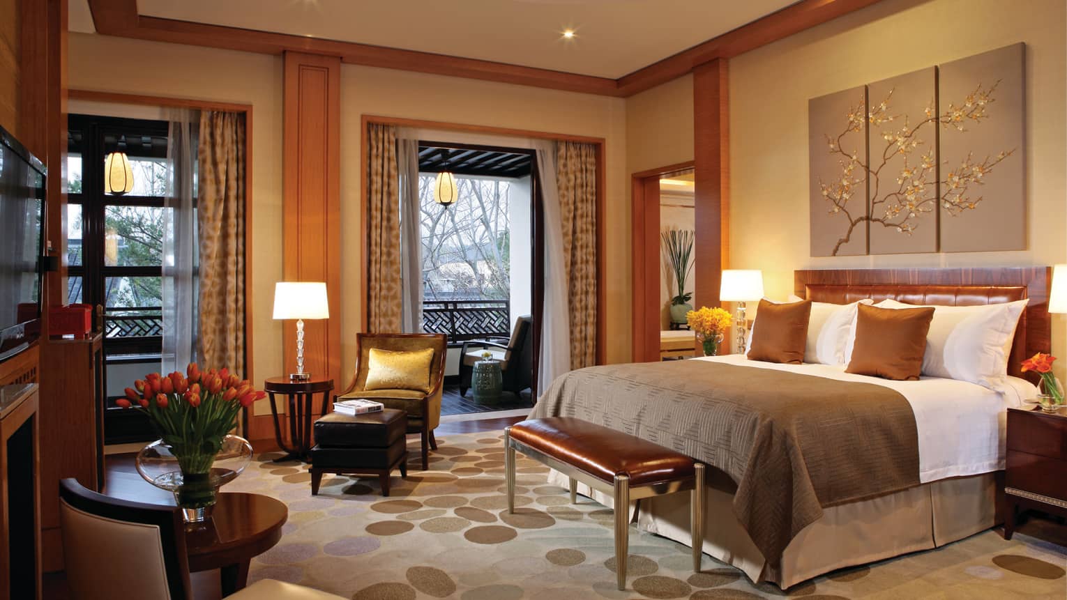 Governor Villa bed with copper pillows, blanket, small leather bench by seating areas, double windows