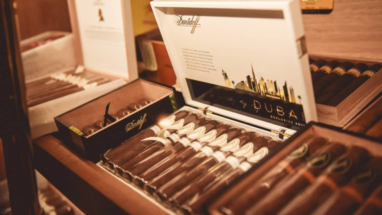 Cigars wrapped in plastic line boxes on shelf