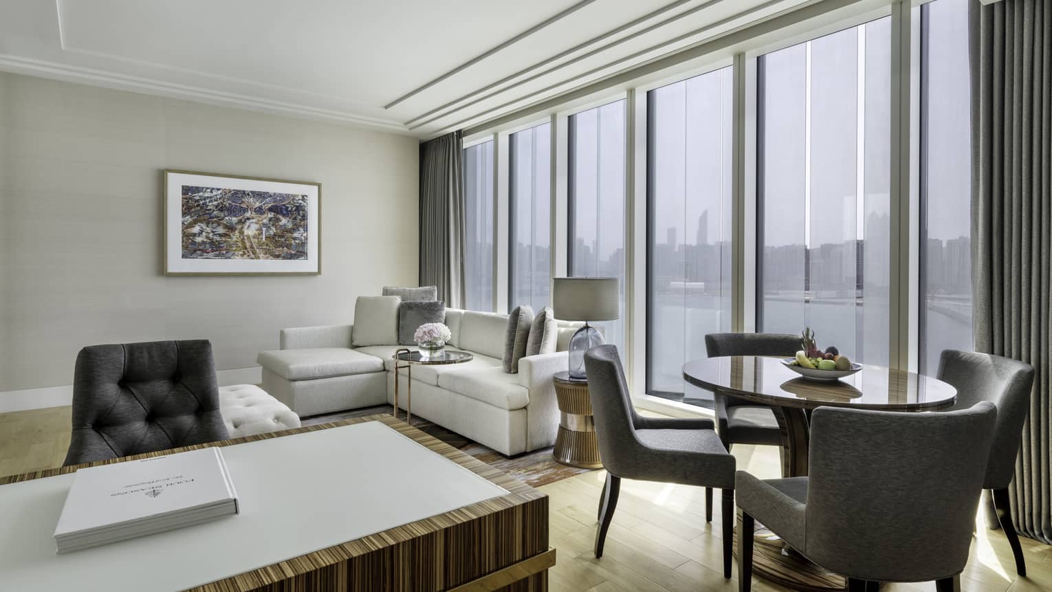 Luxury hotel suite living room with round dining table and desk