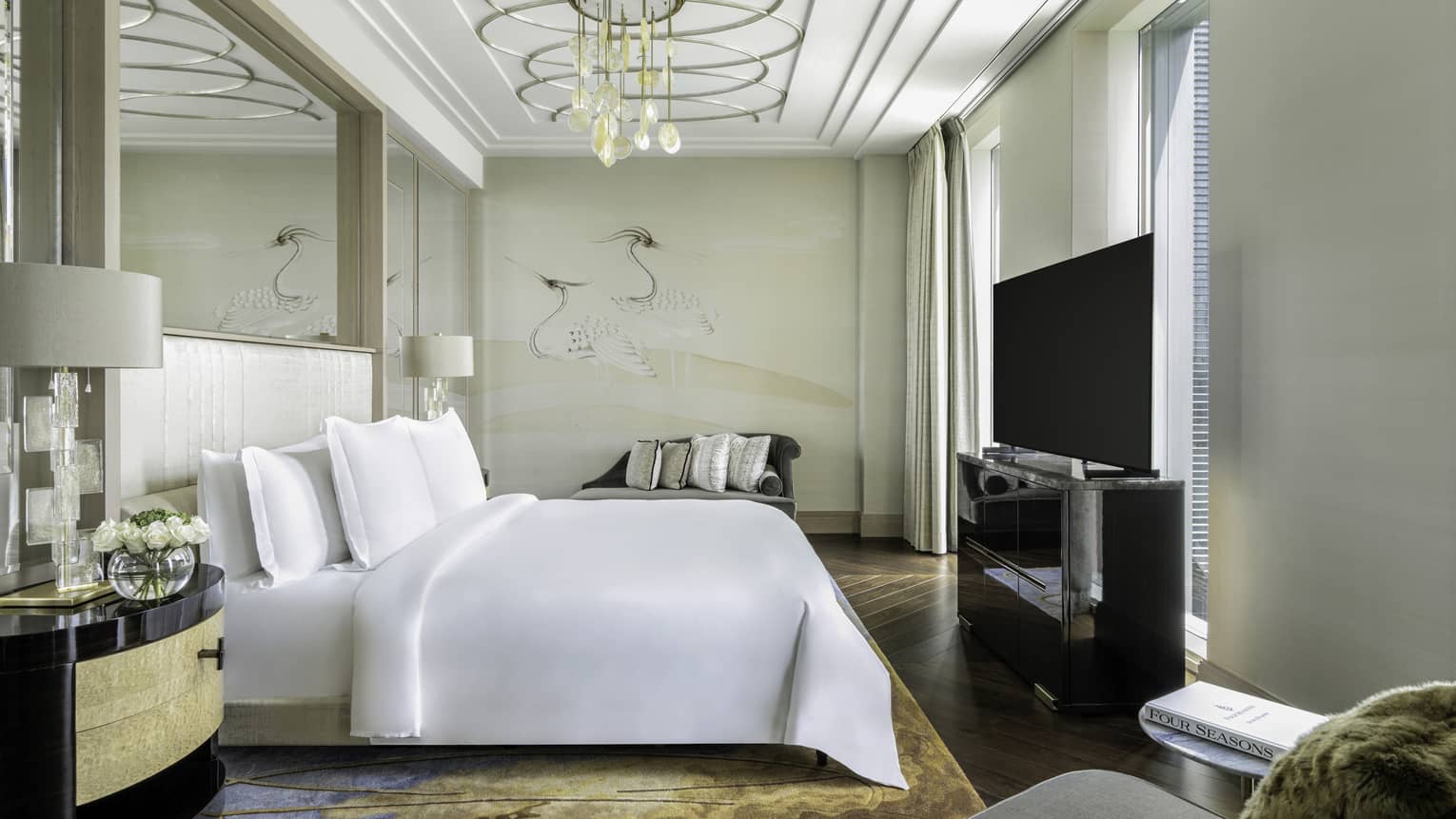 Luxury hotel suite bedroom with king bed and chandelier