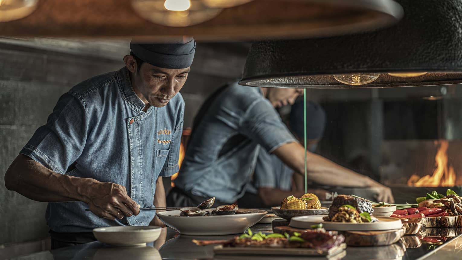 Two chefs put finishing touches on dishes at Sundara