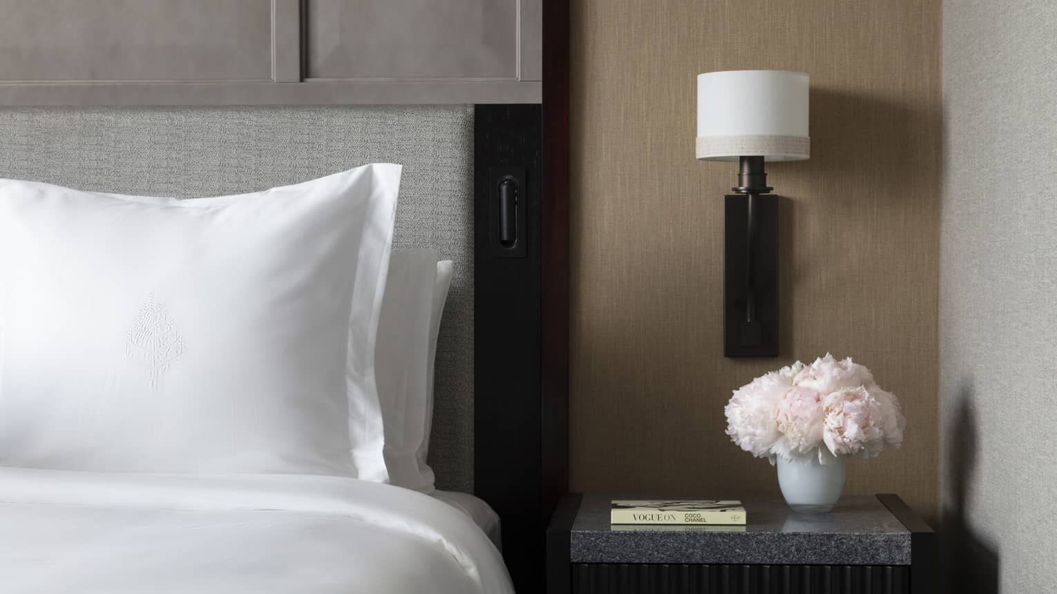 Sleek bedside table next to a crisp white Four Seasons bed