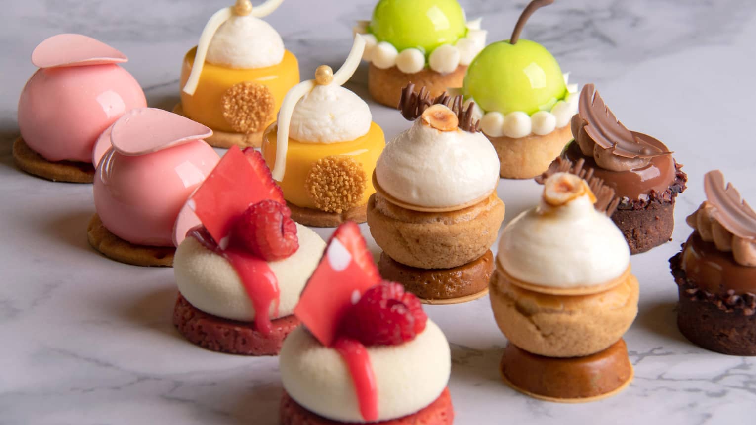 Pink, cream and brown cookies garnished with a scoop of ice cream and raspberries