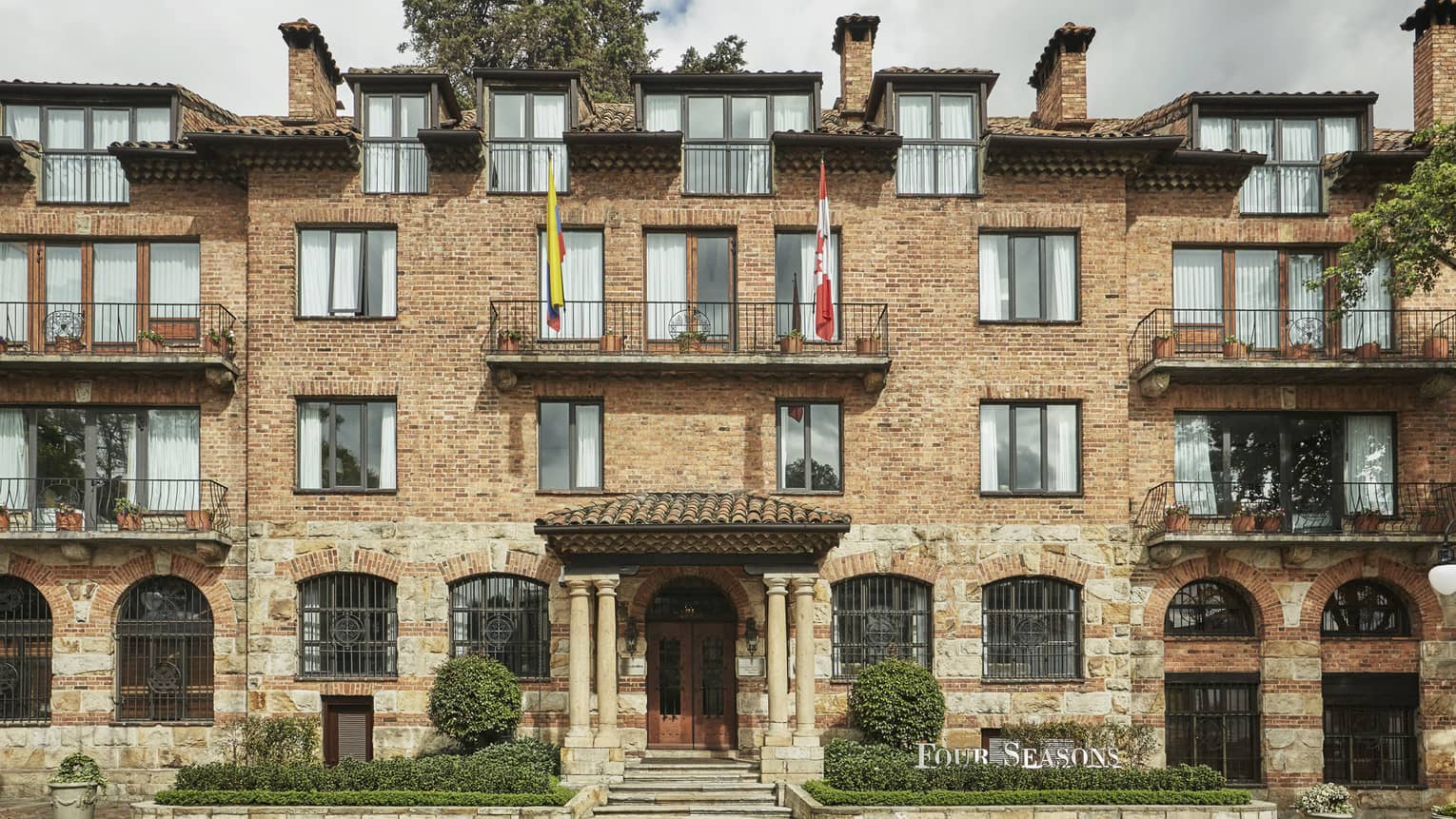 Four Seasons Hotel Casa Medina Bogota brick exterior with balconies, flags