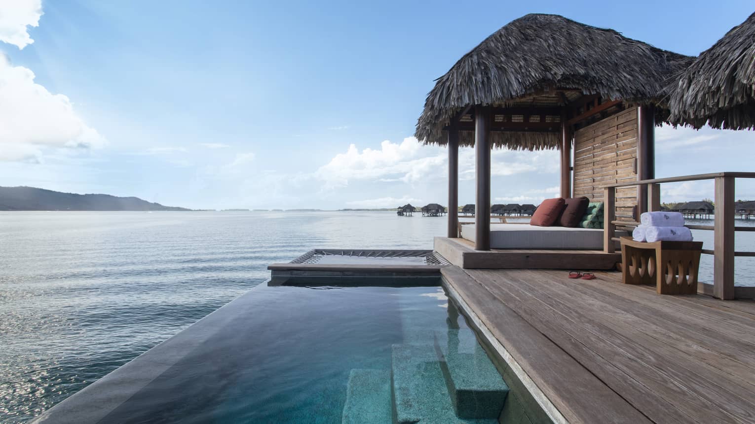 Private deck of Bungalow, with infinity pool and thatched-roof sun bed