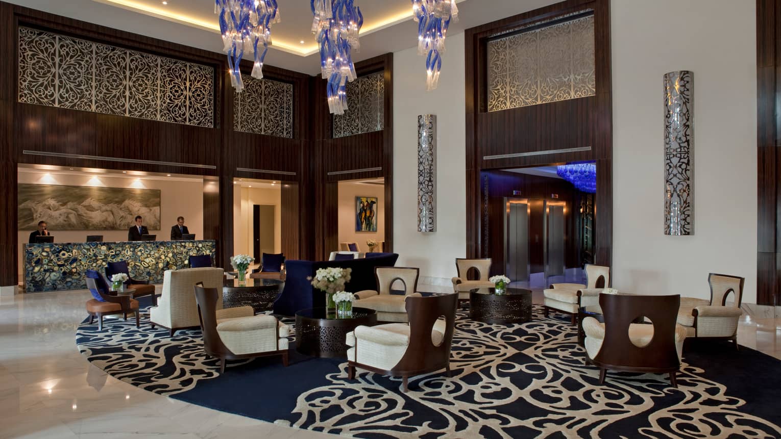 Four Seasons Buenos Aires hotel elegant lobby with armchairs on blue-and-white carpet, under modern chandeliers