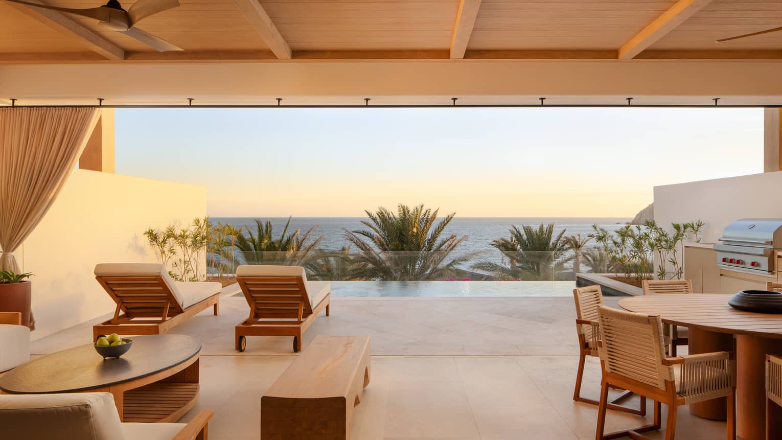 Covered, modern terrace with dining and lounge seating, plus an infinity pool overlooking sea