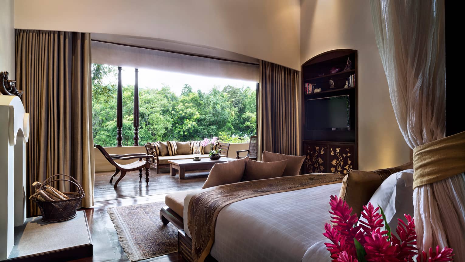 Residence Villa bed from behind canopy, curtains along open wall to balcony with loveseat, chairs