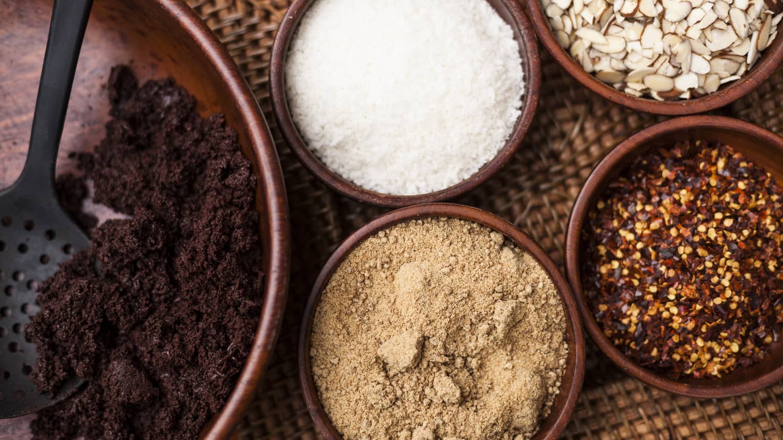 Small bowls of ground roasted cocoa beans, sugar, red chiles