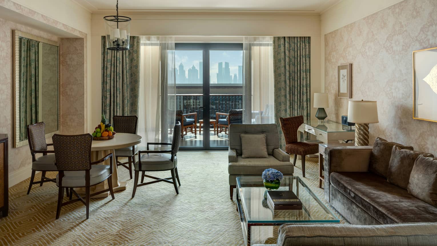 Living room with grey velvet sofa, dining table with four chairs