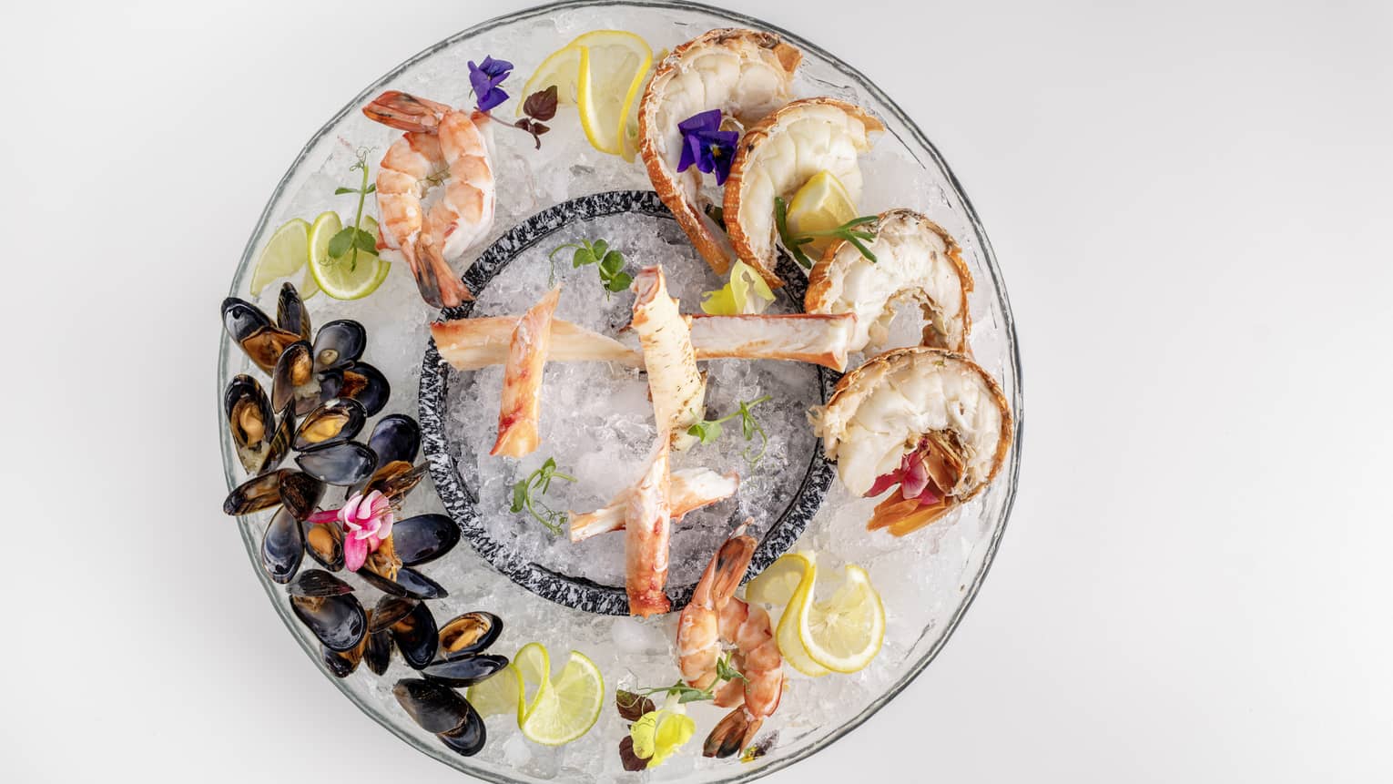  Makani Seafood Platter featuring king crab, lobster, prawns and mussels garnished with lemon slices and flowers