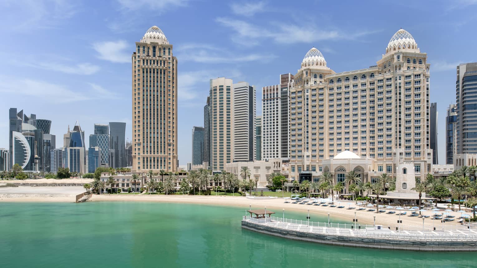 A large building next to water and a pier.
