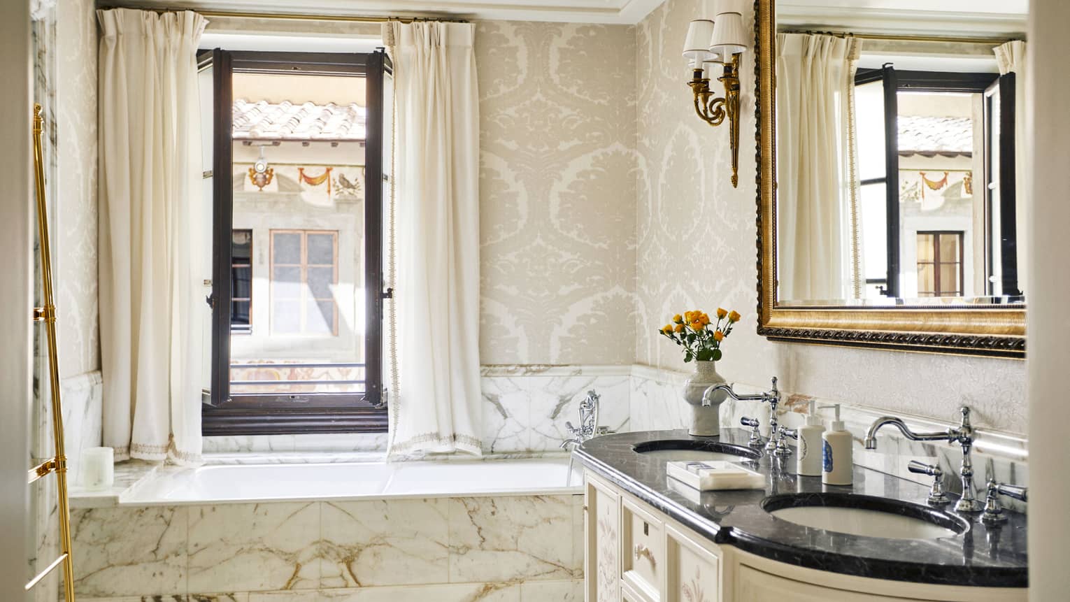 Suite bathroom with window, beige patterned wallpaper, marble tub and ornate vanity, at Four Seasons Hotel Florence