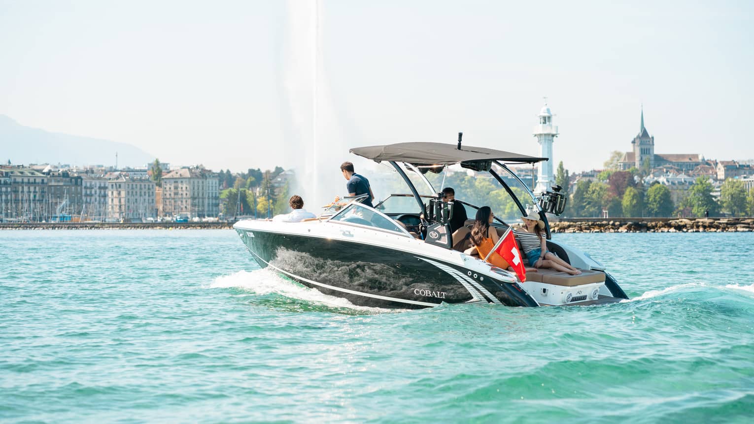 Group of friends in motorboat on Lake Geneva near the Jet d'Eau fountain
