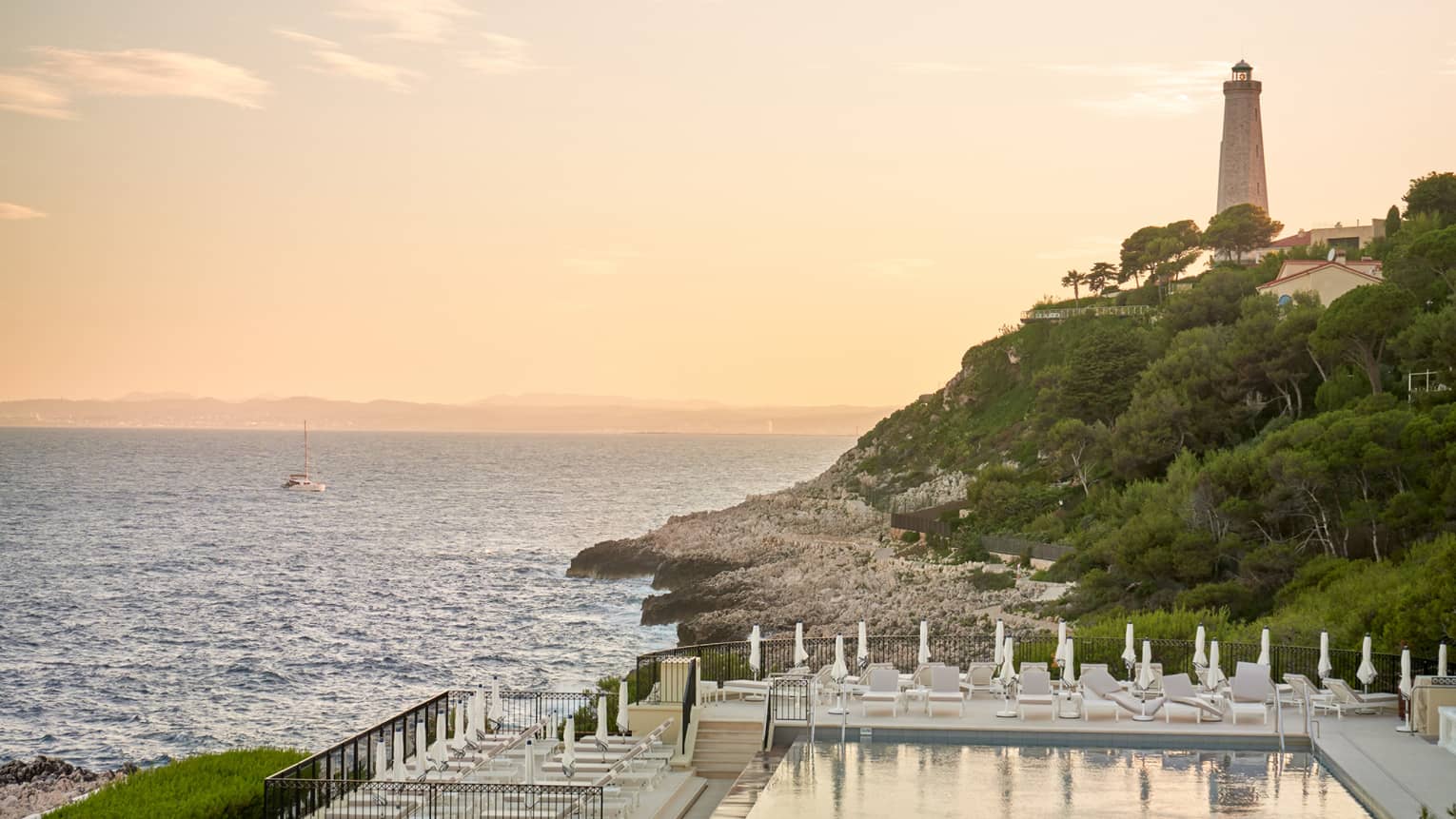 Club Dauphin pool, sea and lighthouse view at sunset
