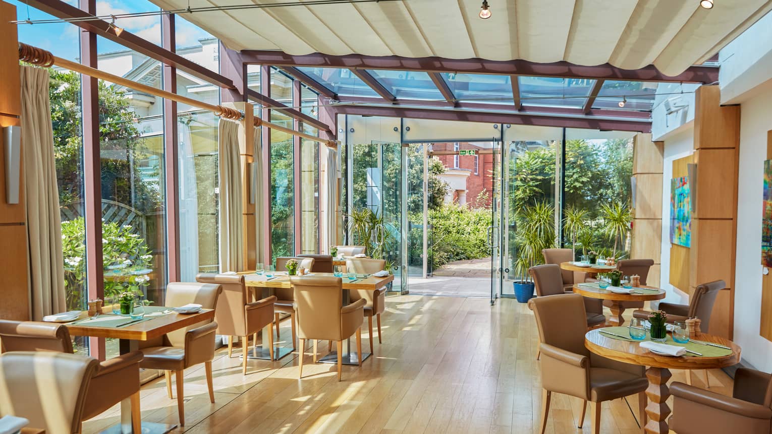 Light-filled restaurant with hardwood floors and brown leather chairs