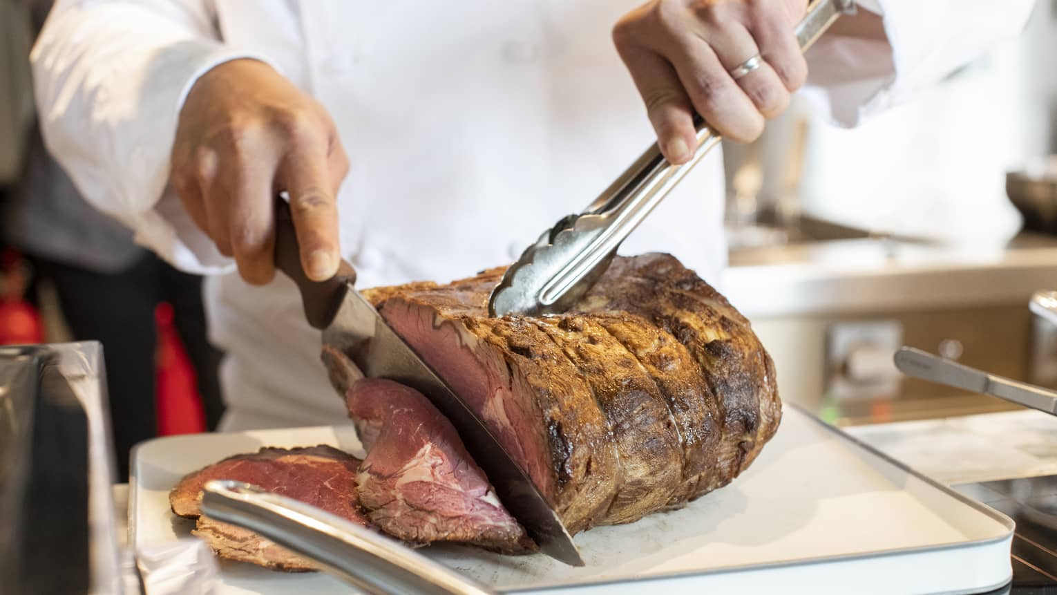 Person carving a prime rib roast