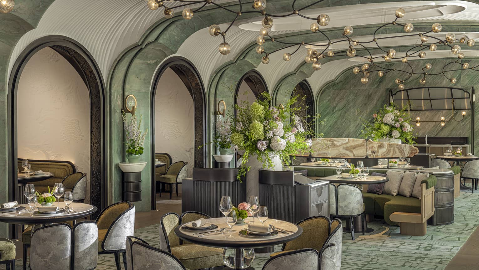 Stylish interiors of Chinese restaurant Song, with turquoise carpet and walls, arched entryways into dining areas and modern lighting fixture, Four Seasons Hotel Hangzhou at Hangzhou Centre
