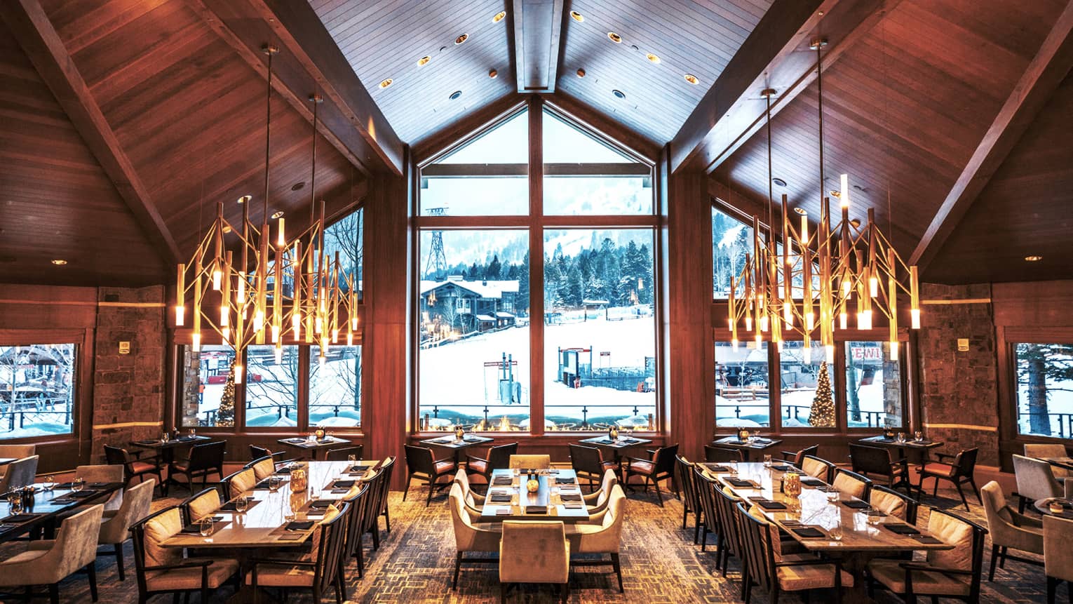 The spacious Westbank Grill dining room revealing ample seating, large windows, and mountainous surroundings.