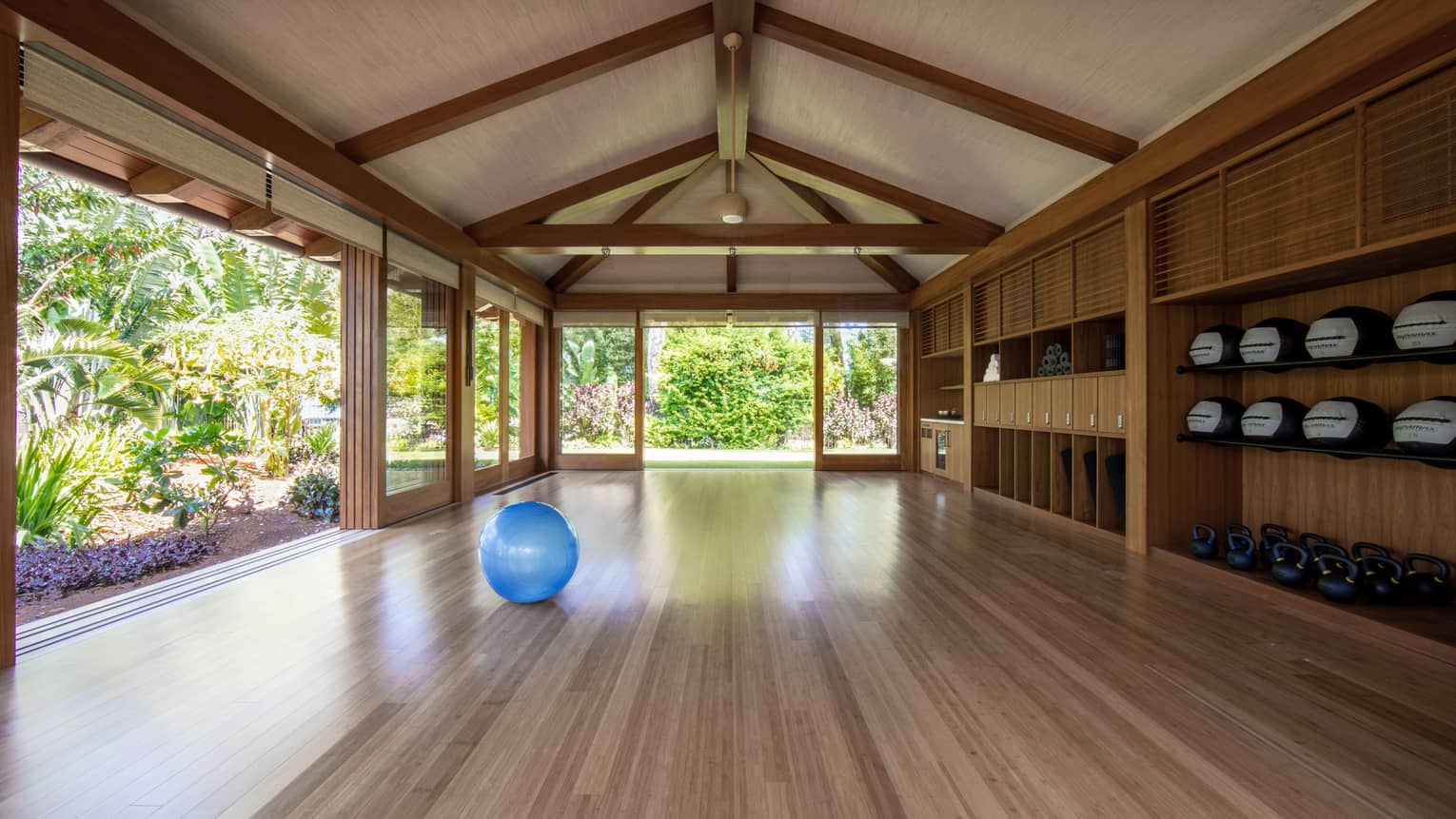 Fitness studio with wooden beams, walls and floors, huge openings to the outside