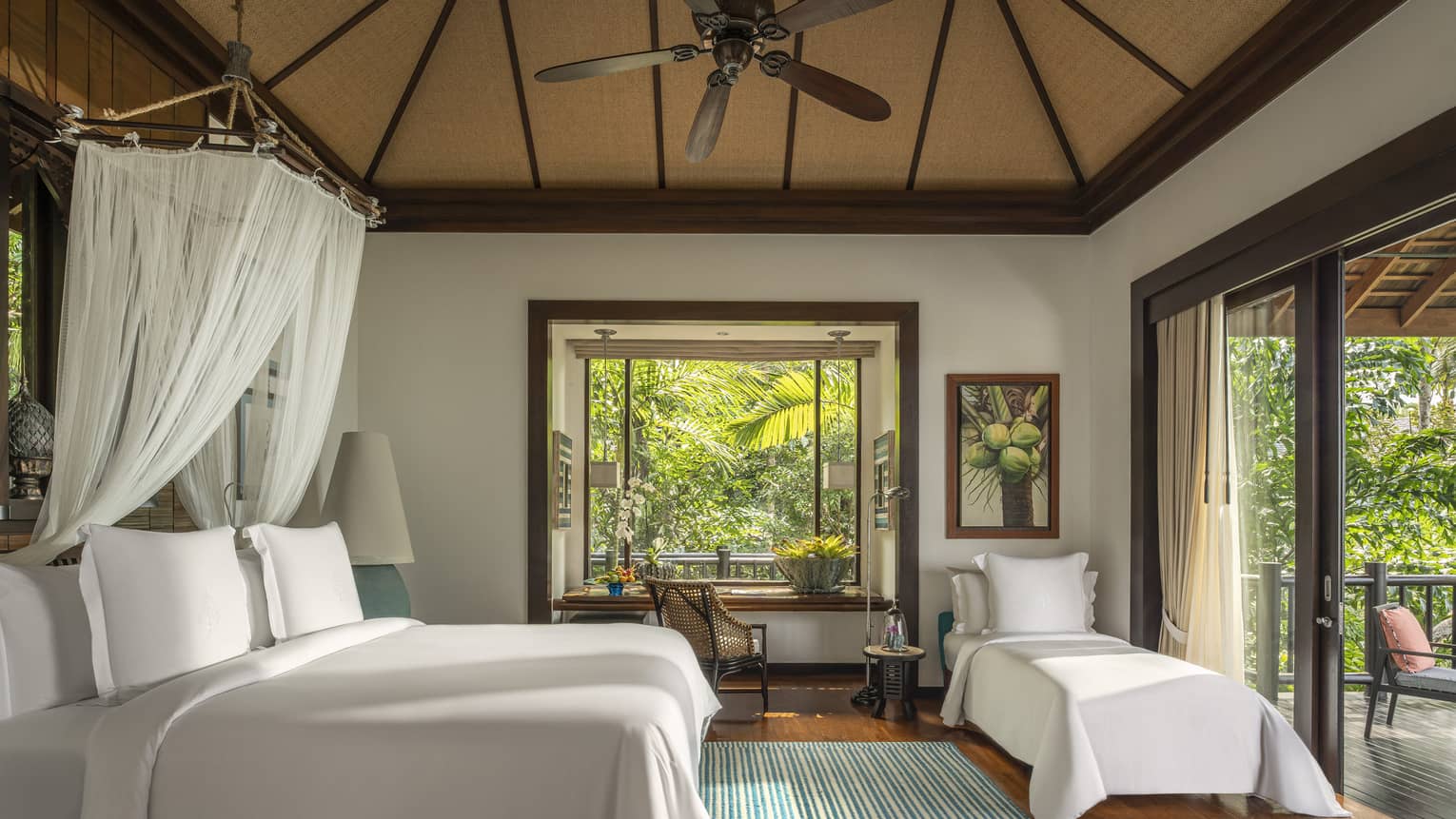 Bedroom in tropical villa, with king bed, net canopy and extra twin bed
