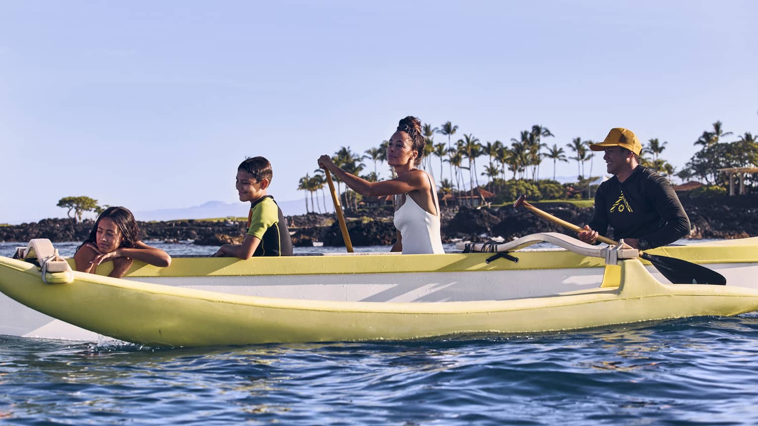 Man, woman and two young children in an outrigger canoe in Hawaii