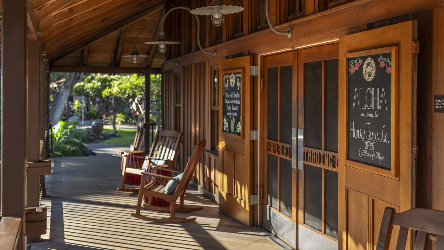 Exterior porch and entrance into a cafe, with wooden doors and wooden rocking chairs