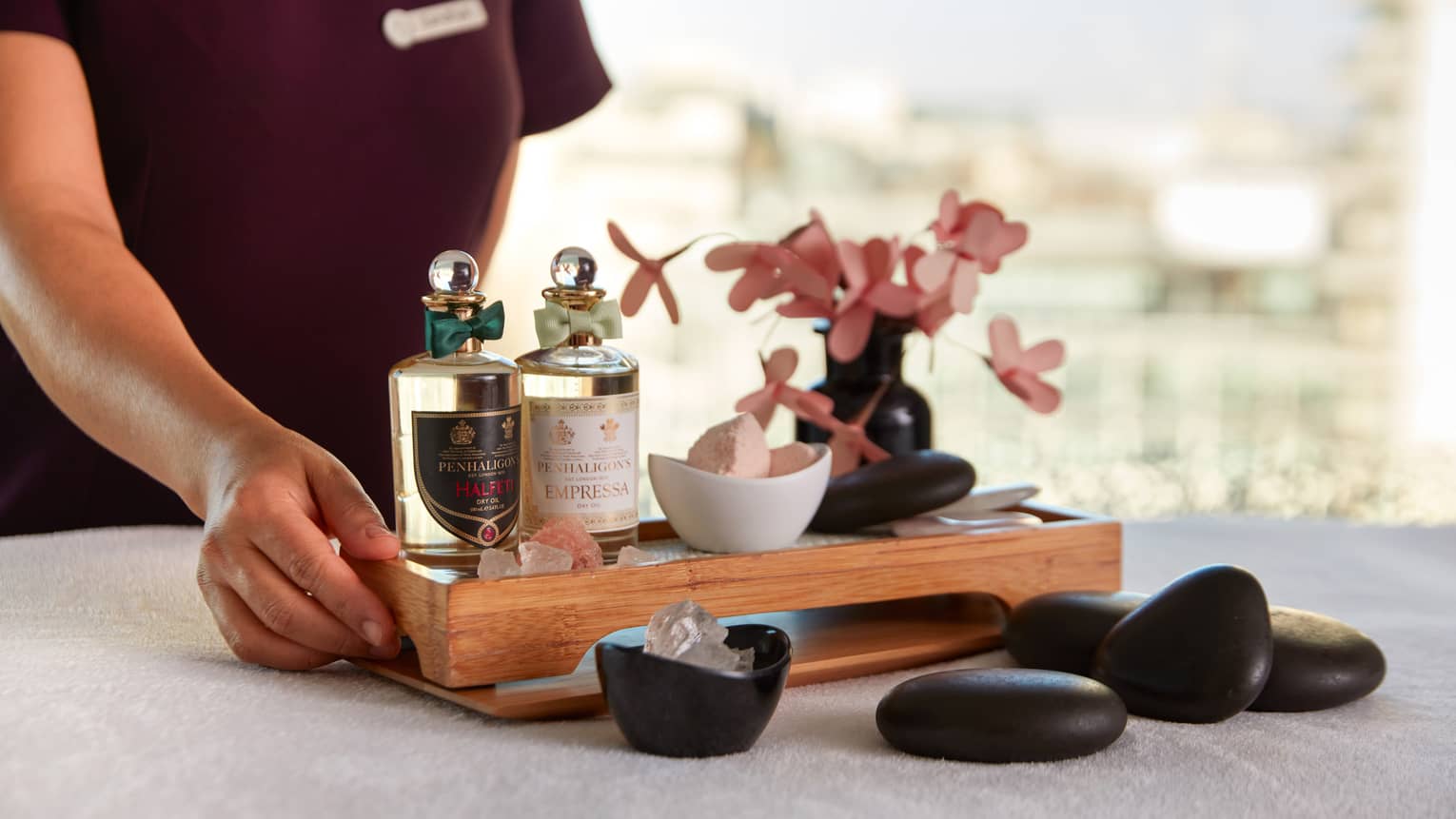 Spa minerals and material on a wooden tray.