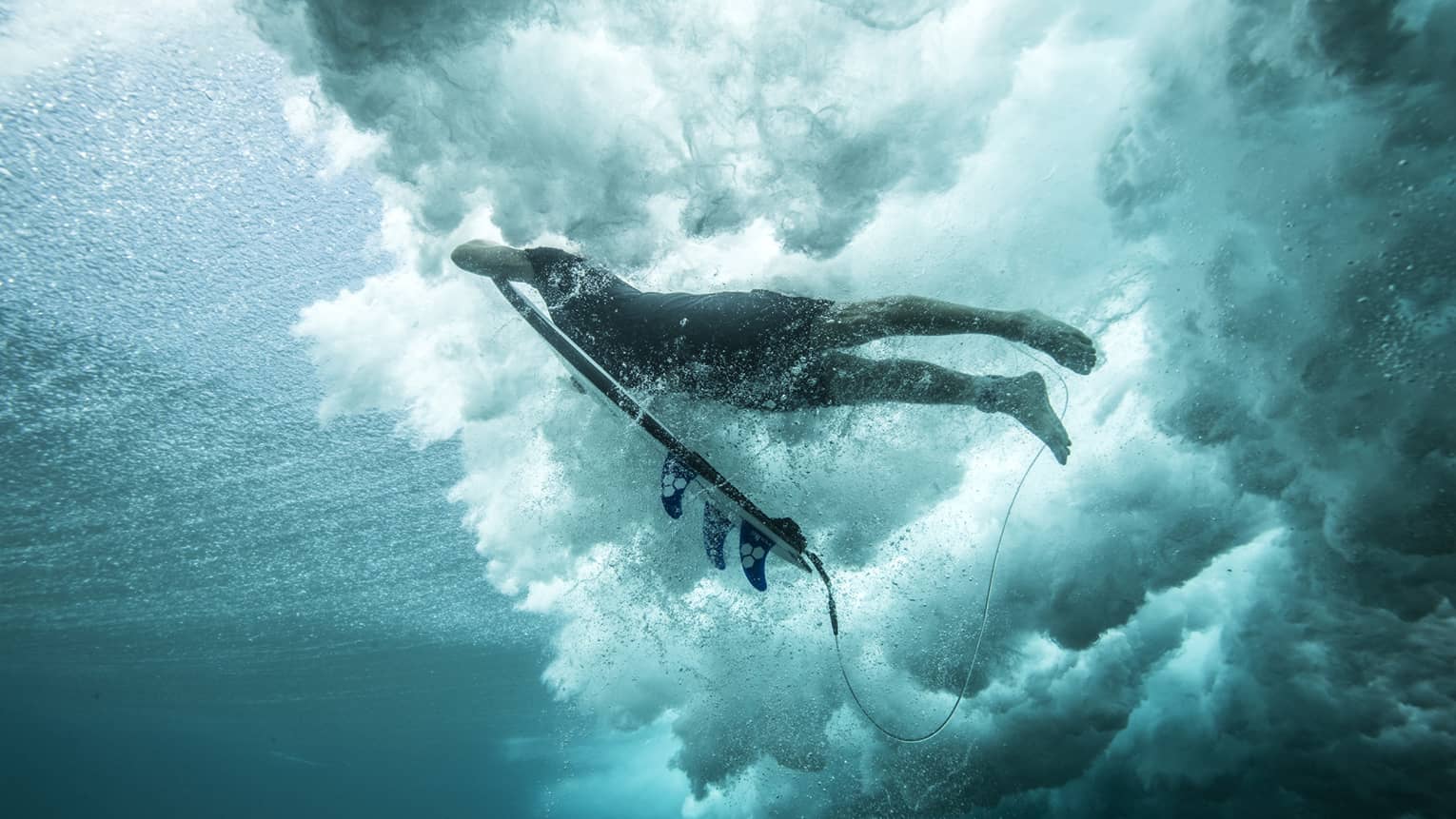 Angled shot of Tropicsurf pro breaking the surface of a wave 