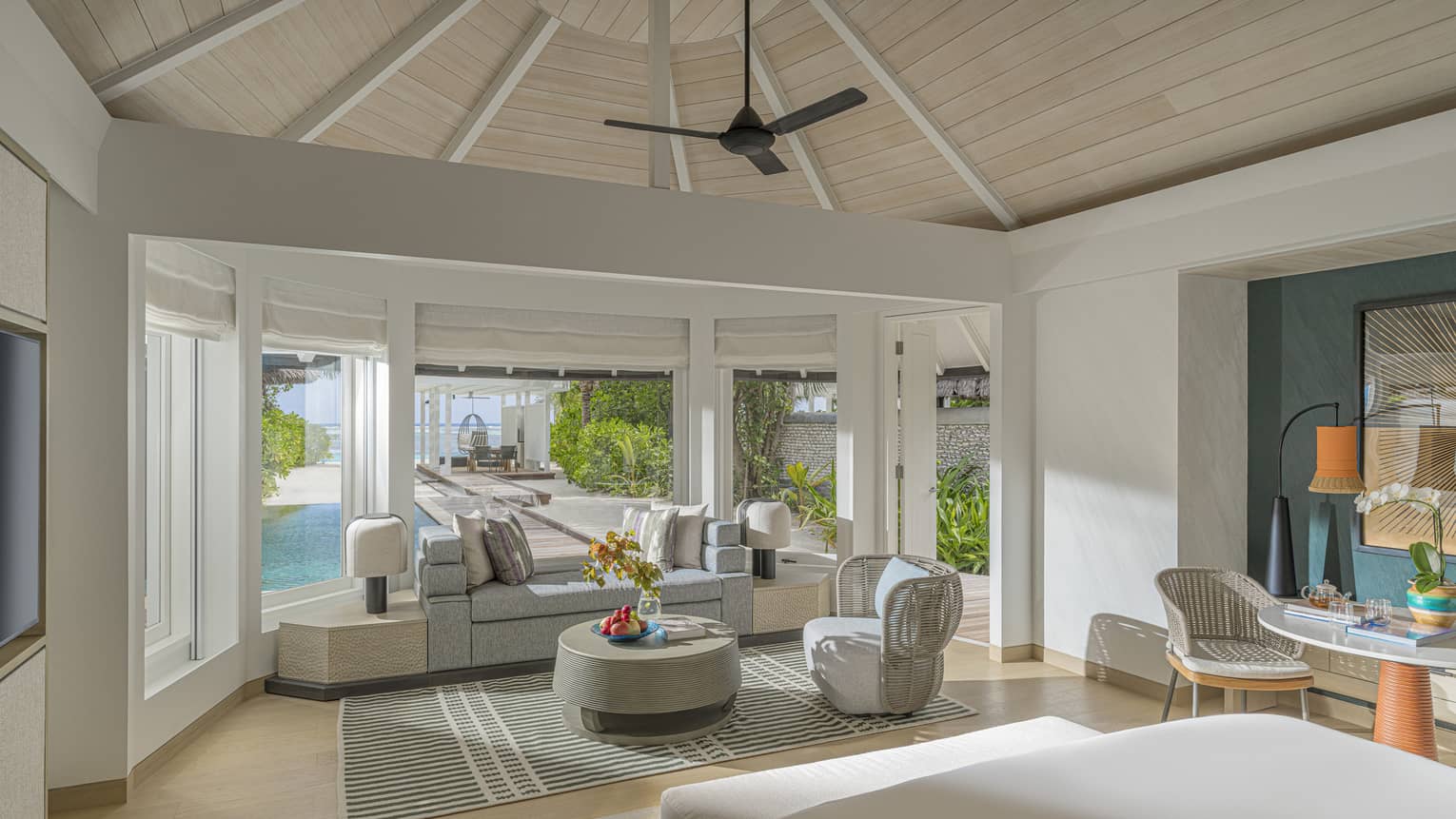 Interior bedroom with sitting area and vaulted ceiling in a luxury villa at tropical resort
