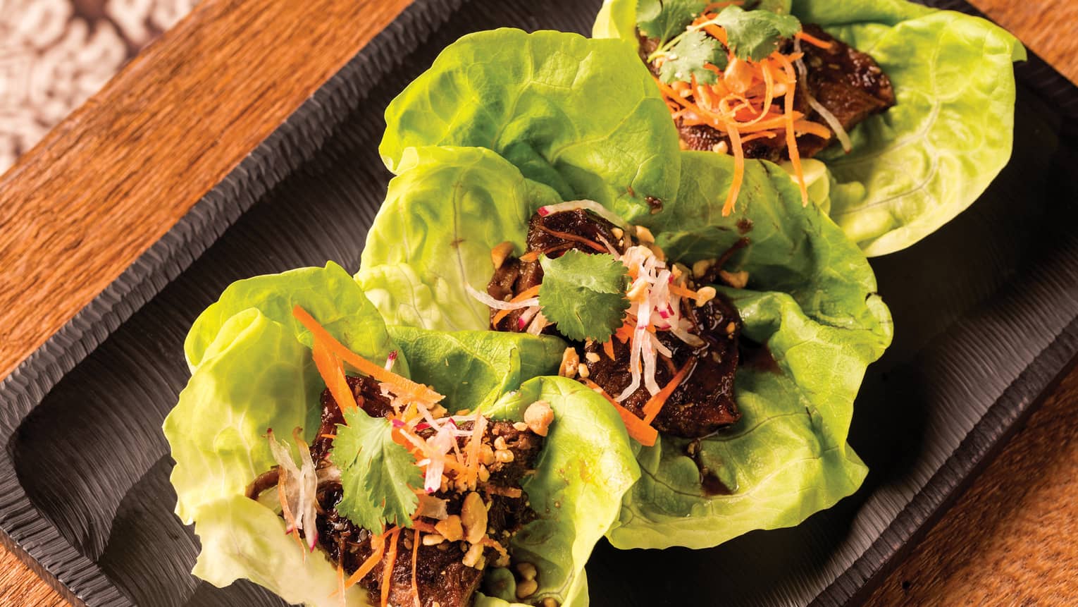 Three Kalbi Rib Lettuce Wraps with braised short ribs on platter