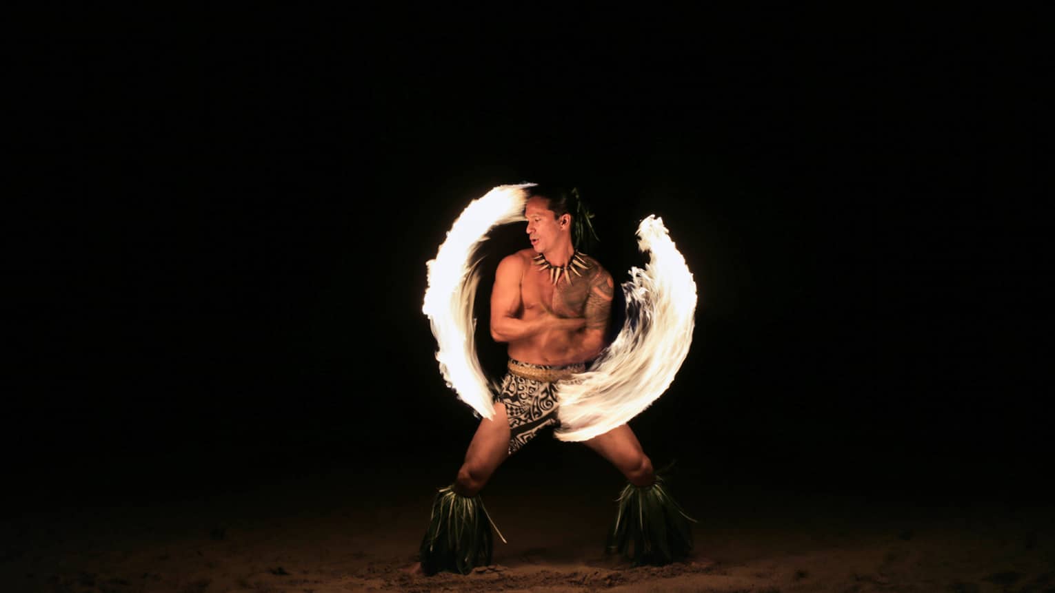 Fire dancer spins fire on the beach