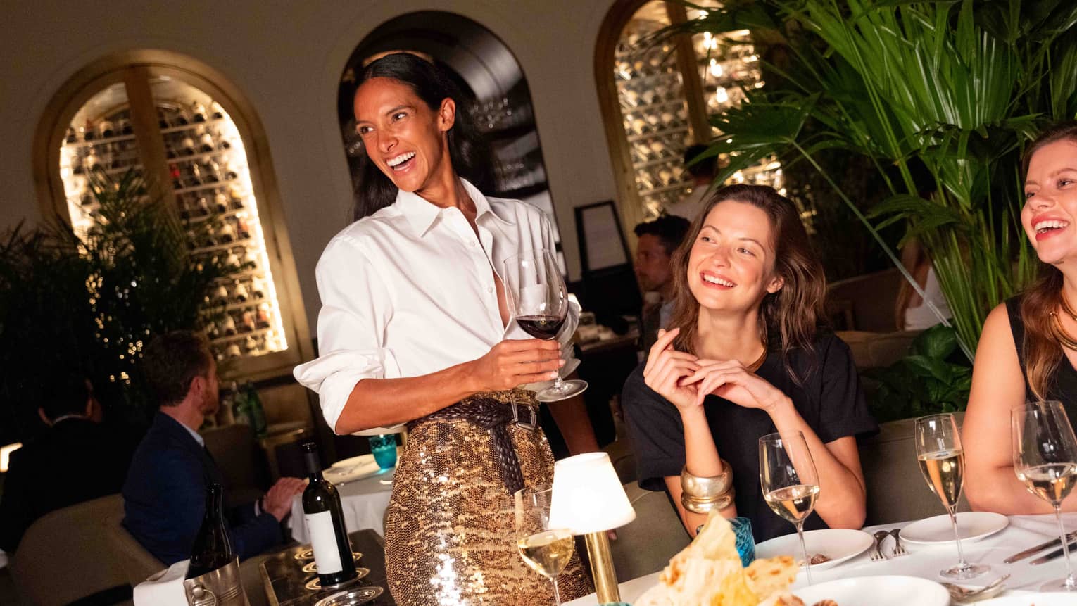 A group of people gathered at a dining table and smiling at one another